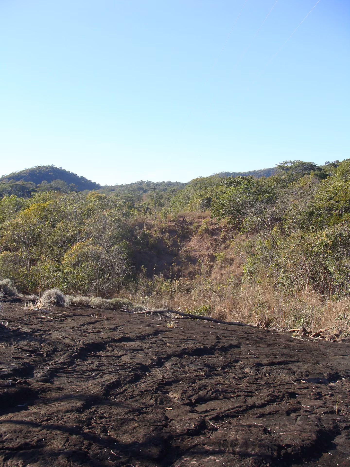 O lajedo do Sítio Arqueológico, com o Cerrado e a serra ao fundo